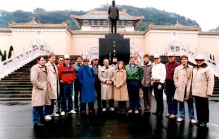 A group of people standing in front of a statue.