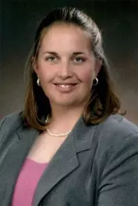 A woman in a gray jacket and pink shirt