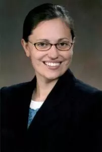 A woman with glasses and a jacket on.