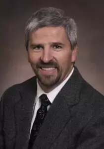 A man with gray hair and a suit.