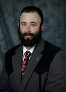 A man with a beard and suit jacket