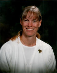 A woman with long blonde hair wearing white shirt.
